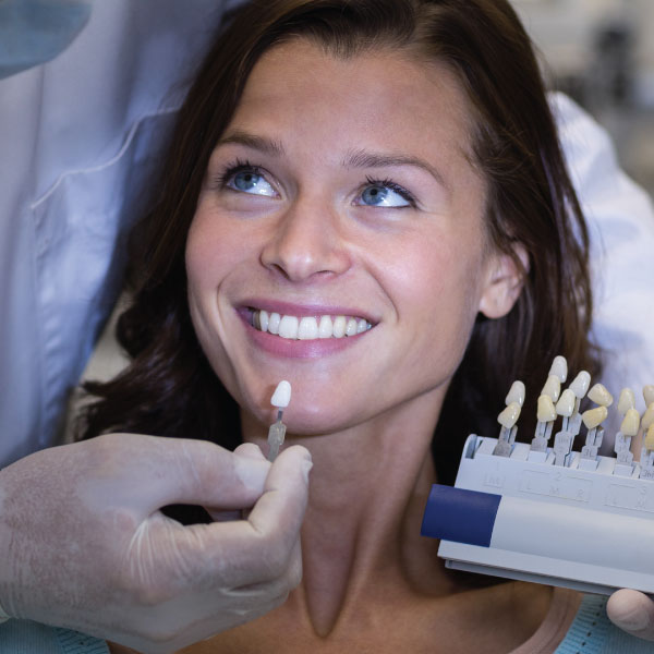 Attractive Young Woman Getting Evaluated for Veneers at a Dentists Offiice